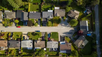 An aerial view of a street lined with houses that ends in a cul de sac